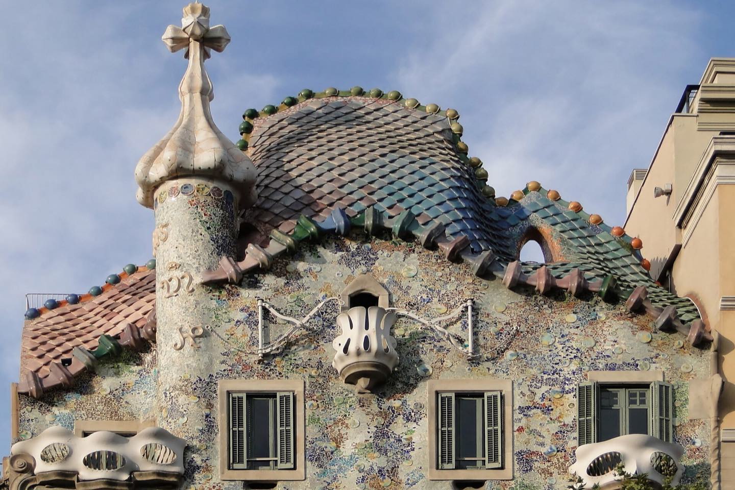 The tiled dragon-scale roof and cross-topped turret of Casa Batlló