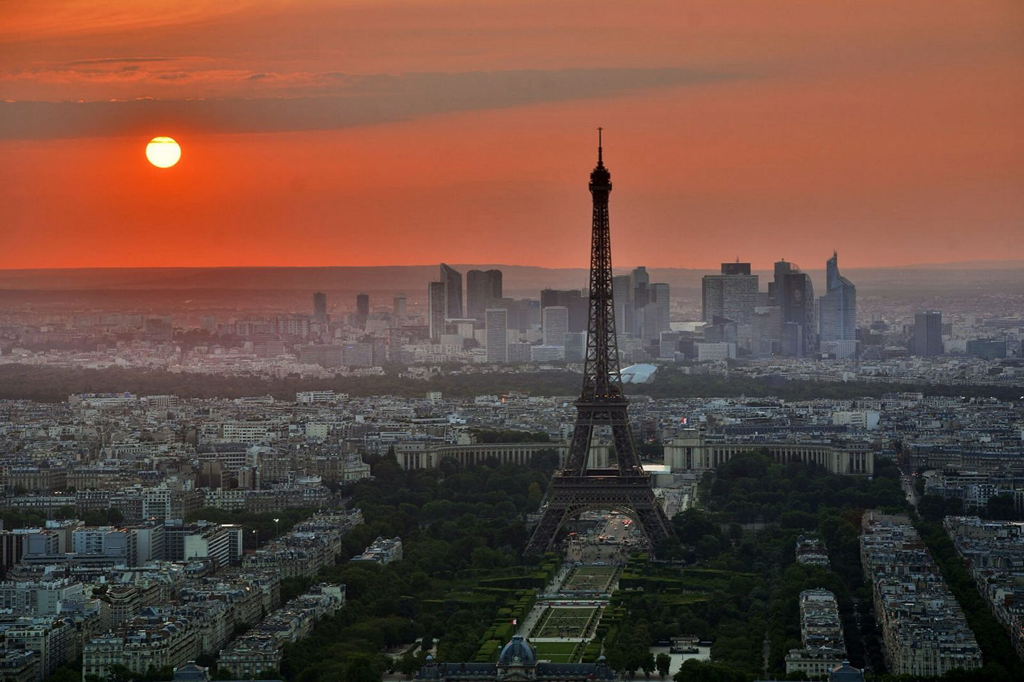 The Eiffel Tower rising above rooftops at golden hour