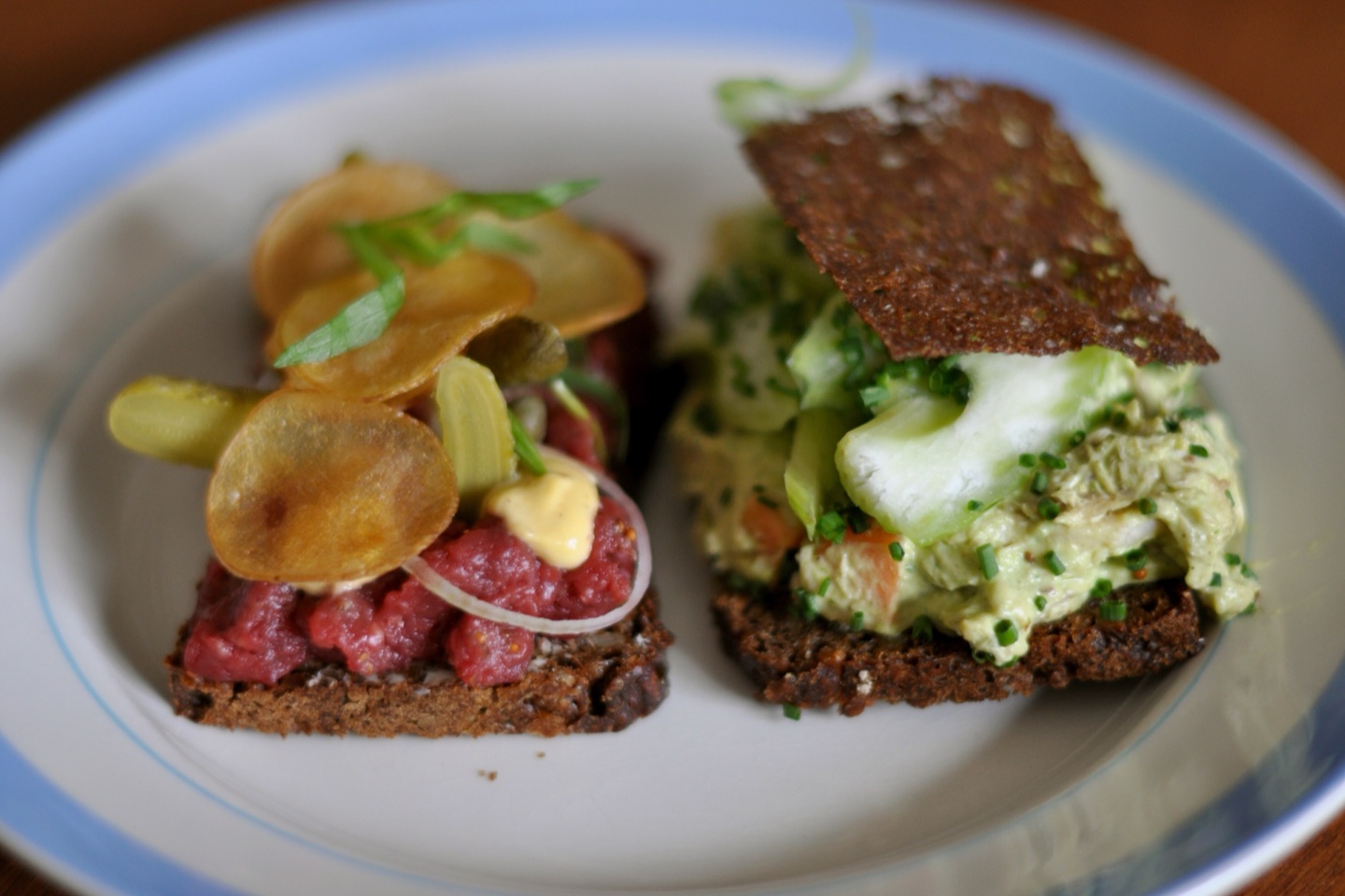 Two open sandwiches on rye bread, beef tartare and chicken salad