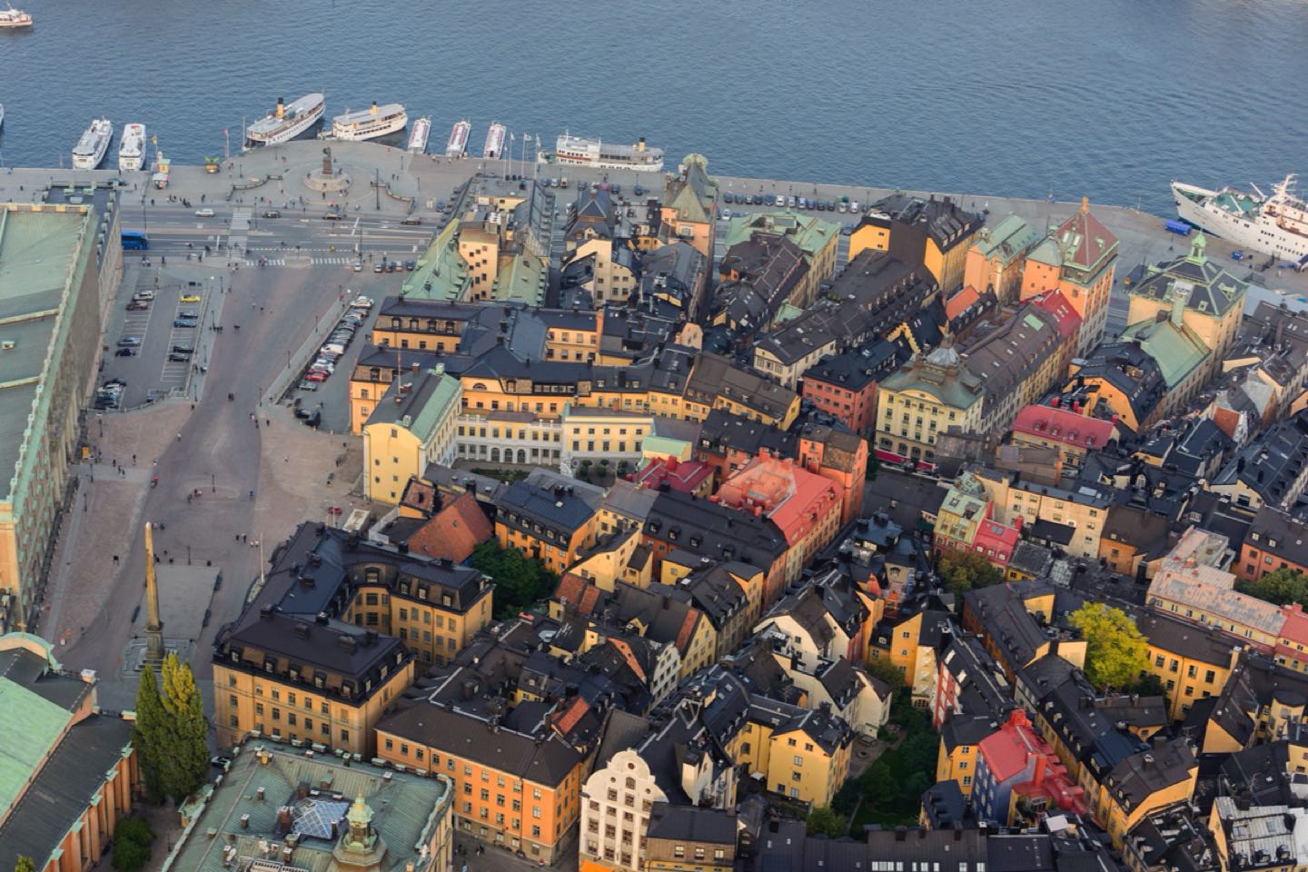 Aerial view of the yellow and ochre houses of Gamla stan beside the water