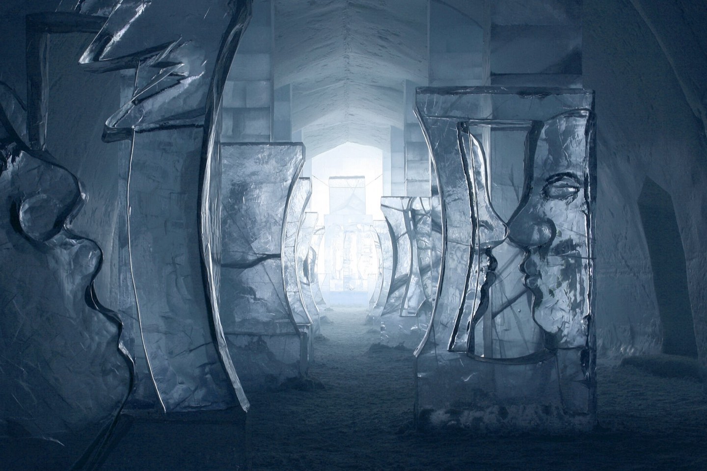 Carved ice sculptures lining the blue-lit main hall of the Icehotel