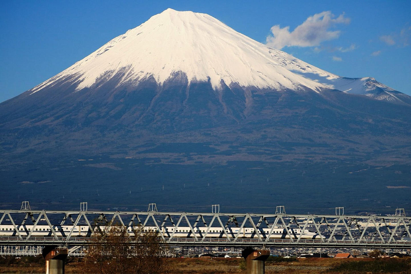 A Shinkansen bullet train passing below Mount Fuji