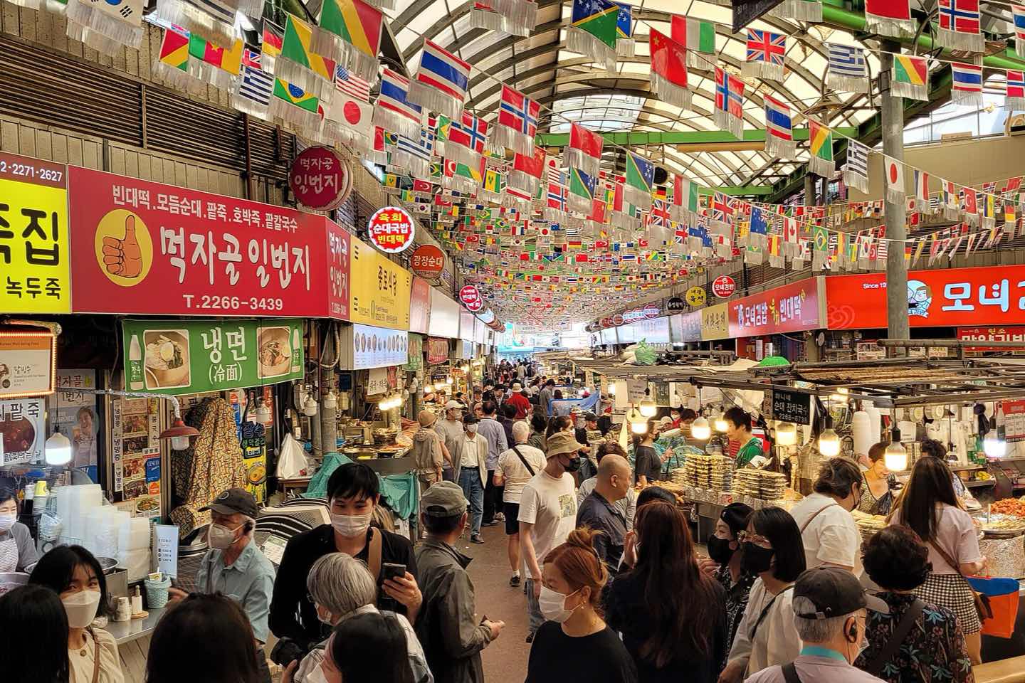 Crowds and food stalls under the arched roof of Gwangjang Market, Seoul
