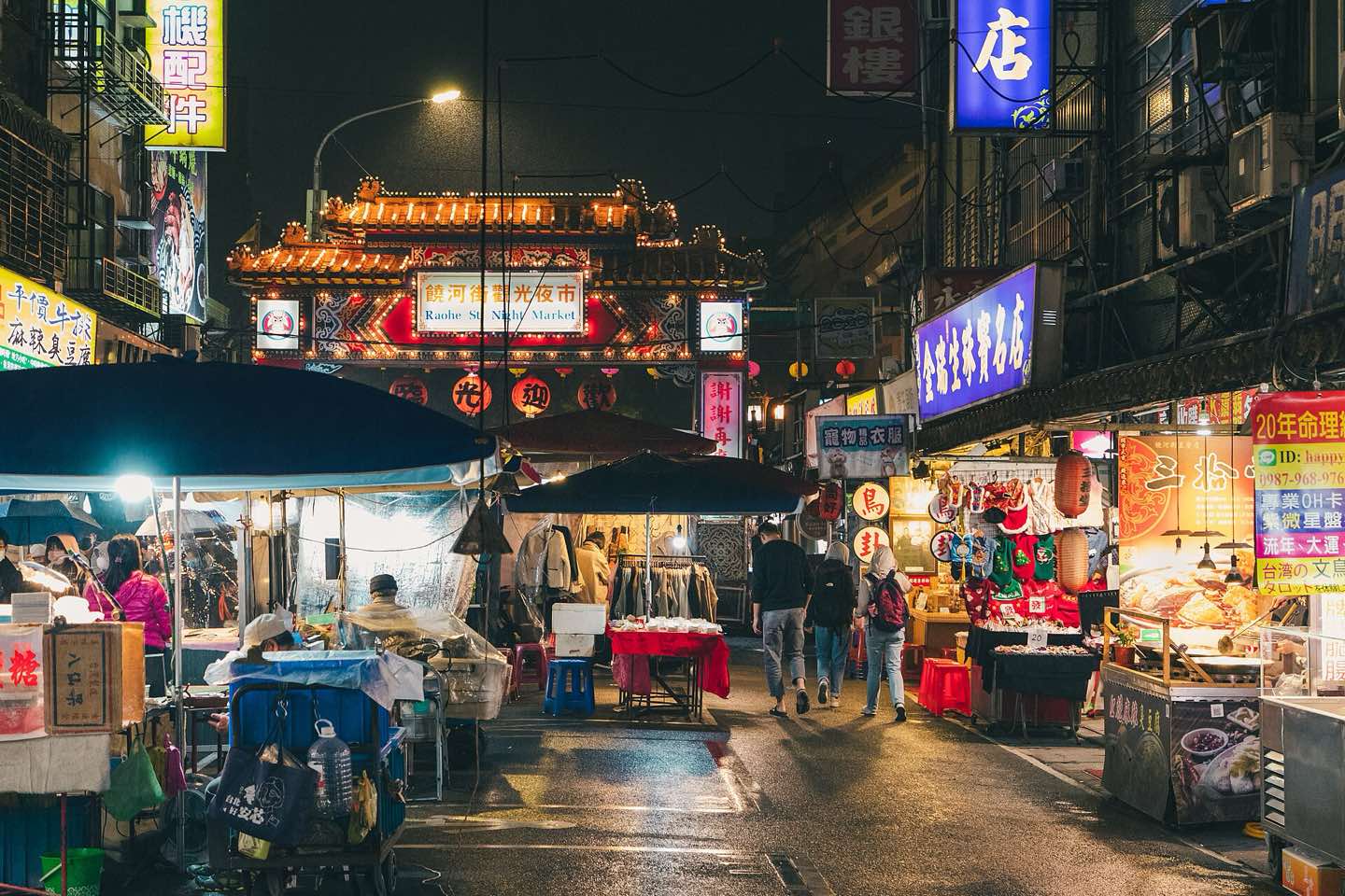 Stalls and lanterns at Raohe Street Night Market below the Ciyou Temple gate