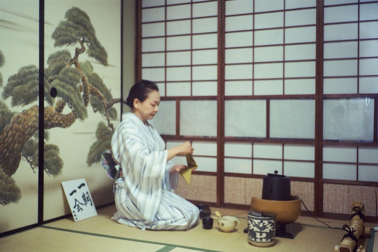 A host in kimono preparing matcha during a tea ceremony in Kyoto