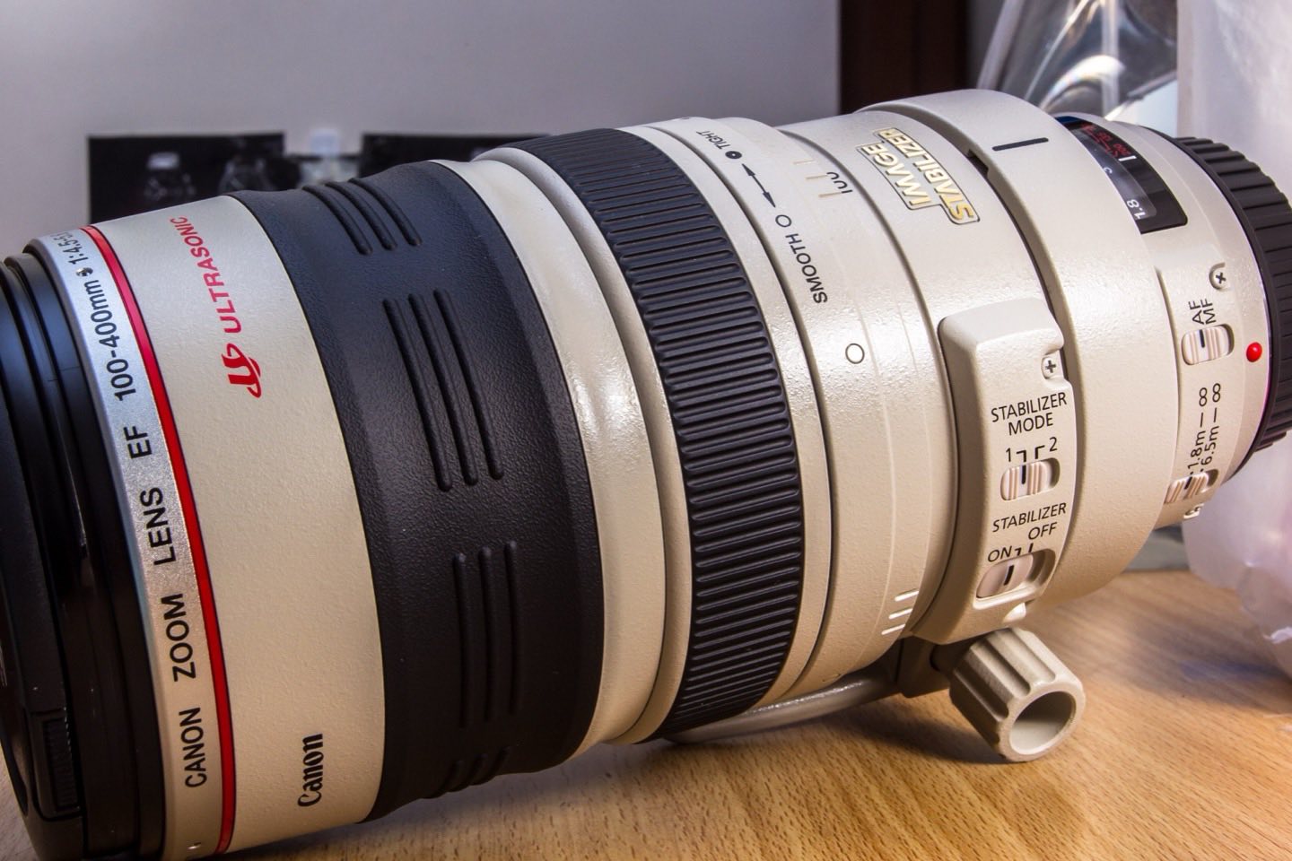 A 100–400 mm telephoto zoom lens on a desk